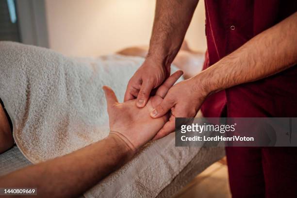 man receiving a hand massage - hand massage stock pictures, royalty-free photos & images