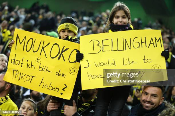 Young fans of Borussia Dortmund hold signs about players' jerseys ahead of the Bundesliga match between Borussia Mönchengladbach and Borussia...