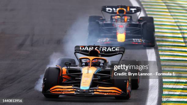 Daniel Ricciardo of Australia driving the McLaren MCL36 Mercedes locks a wheel under braking in front of Max Verstappen of the Netherlands driving...