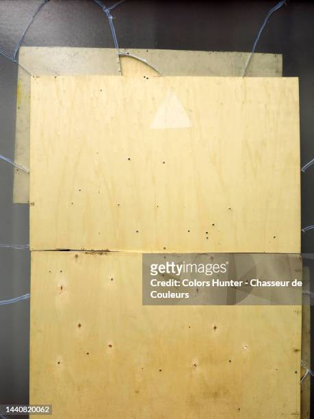 close-up of a wooden panel on a broken window in paris - empty store window stock-fotos und bilder