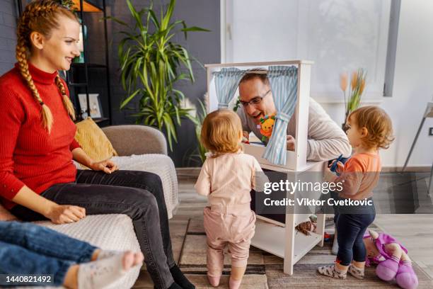 loving father performing puppet show at home for his little daughters - puppet stockfoto's en -beelden