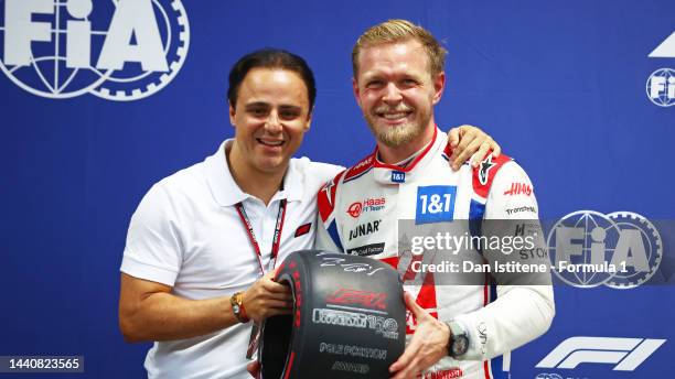 Pole position qualifier Kevin Magnussen of Denmark and Haas F1 is presented with the Pirelli Pole Position trophy by Felipe Massa during qualifying...