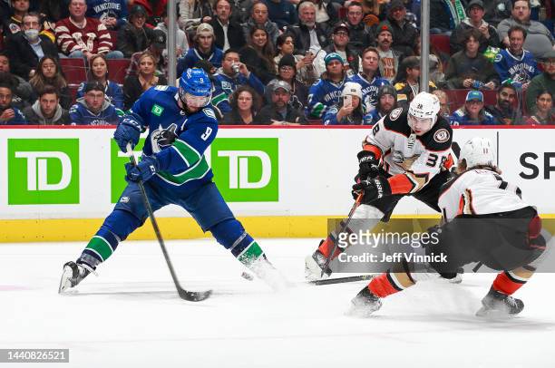 Trevor Zegras and Derek Grant of the Anaheim Ducks check J.T. Miller of the Vancouver Canucks during their NHL game at Rogers Arena November 3, 2022...