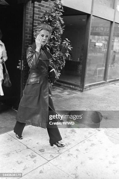 Outtake; Also ran in W 4/7/1972 p.6; Barbara "Babe" Paley leaving a luncheon wearing a burgundy red leather knee-length jacket with striped red...