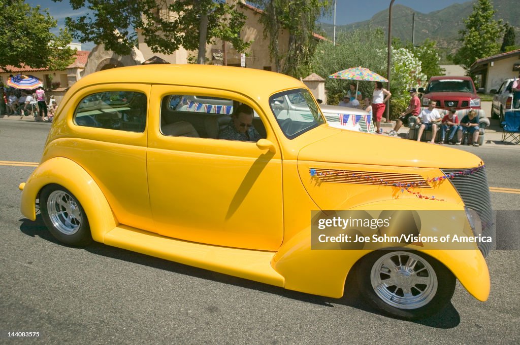 Festive decorated vintage automobile makes its way down main street during a Fourth of July parade in Ojai, CA