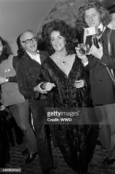 British-American actress Elizabeth Taylor at her fortieth birthday party with personal photographer Gianni Bozzacchi, wearing a black lamb Tiziani...