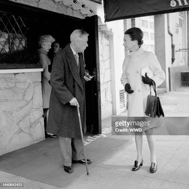 Outtake; The Duke of Windsor, wearing houndstooth and carrying a walking stick and bill fold, standing with his wife, The Duchess of Windsor, dressed...