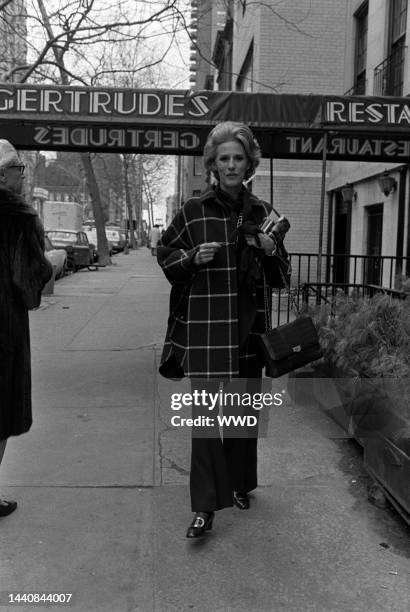 Outtake; Socialite Babe Paley wearing signiture slacks and carrying a Chanel bag while wearing seasonally chic knit gloves and sporting a large plaid...