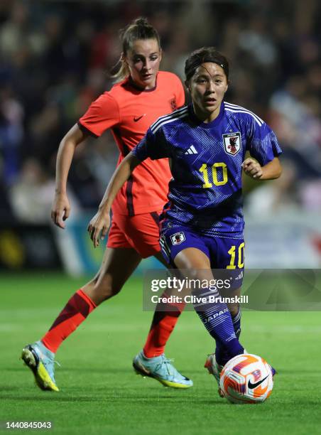 Mana Iwabuch of Japan runs with the ball under pressure from Ella Too of England during the International Friendly between England and Japan at...