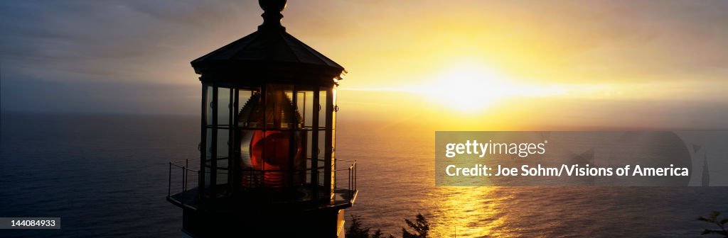 This is the Cape Meares Lighthouse at sunset. It was built in 1890. This shows the very top light inside the lighthouse with its red lamp in the center.