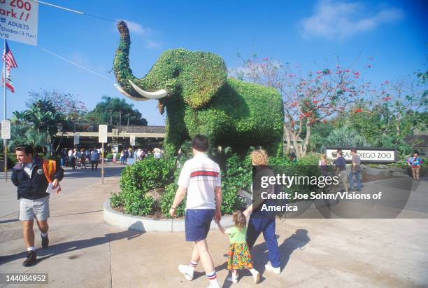 Tourists entering the San Diego Zoo, CA, with elephant topiary