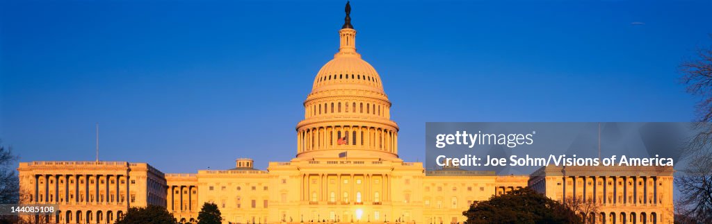 This is the U.S. Capitol at sunset. It is set against a blue sky.