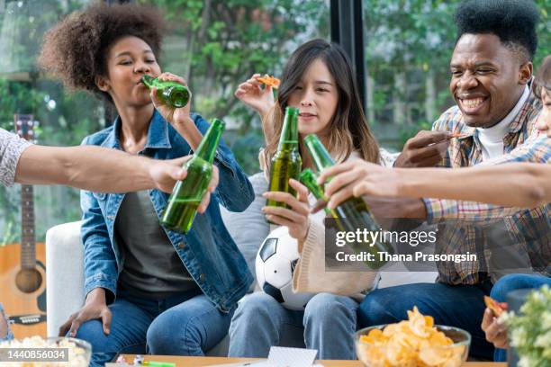 cheerful jouful screaming yelling four soccer fans having day-off resting eating takeaway pizza and drinking beer - finals game four stock pictures, royalty-free photos & images