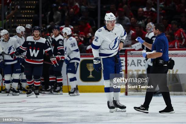 Cal Foote of the Tampa Bay Lightning receives medical attention on the ice after taking a hit to the head against the Washington Capitals during the...