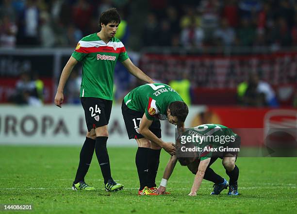 Iker Muniain of Athletic Bilbao is consoled by team mates Javi Martínez and Inigo Perez at the end of the UEFA Europa League Final between Atletico...