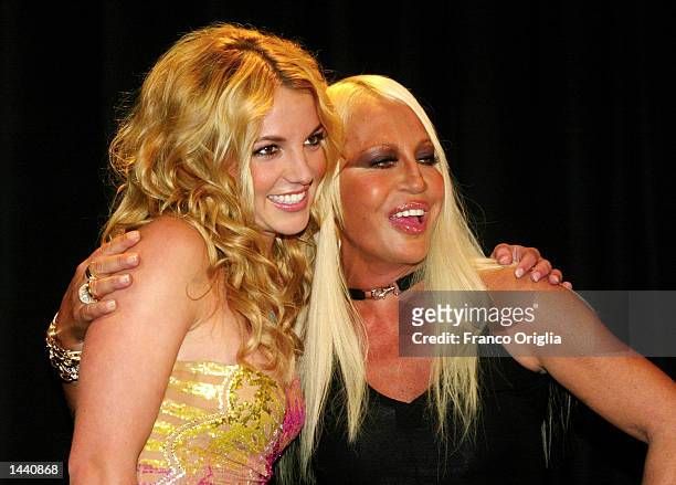 Italian stylist Donatella Versace and american singer Britney Spears acknowledges the applause for Versace's Spring/Summer women's 2003 collection,...