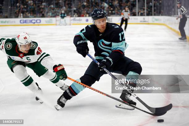 Jaden Schwartz of the Seattle Kraken skates against Jared Spurgeon of the Minnesota Wild during the second period at Climate Pledge Arena on November...