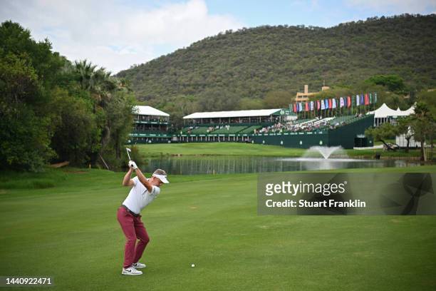 Luke Donald of England plays his approach shot on the 18th hole during the weather delayed second round during Day Three of the Nedbank Golf...