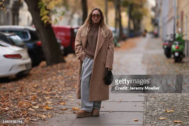 Sonia Lyson seen wearing a The Frankie Shop beige oversized coat and grey joggingpants pants, a Lala Berlin beige knit turtleneck sweater, Ugg...