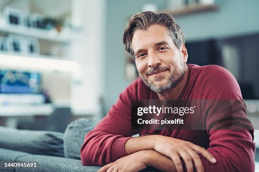Hombre sonriente de mediana edad disfrutando de un momento de relax en casa Hombre sonriente de mediana edad disfrutando de un momento de relax en casa
