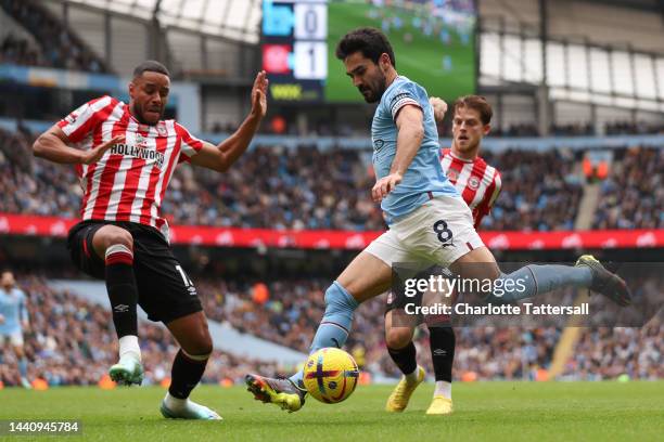 Ilkay Gundogan of Manchester City is challenged by Mathias Zanka Jorgensen of Brentford during the Premier League match between Manchester City and...