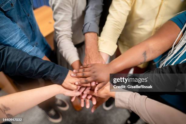 multiracial businesspeople stacking their hands - hand stack stock pictures, royalty-free photos & images