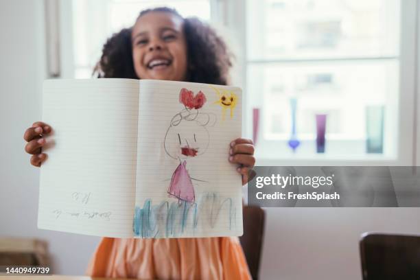 girl proudly showing her drawing - kid presenting stock pictures, royalty-free photos & images