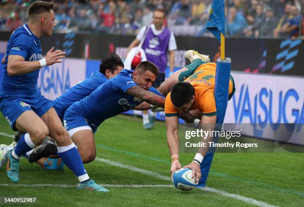 Tom Wright of Australia scores a try as Pierre Bruno tries to push him into touch during the Autumn International match between Italy and Australia...