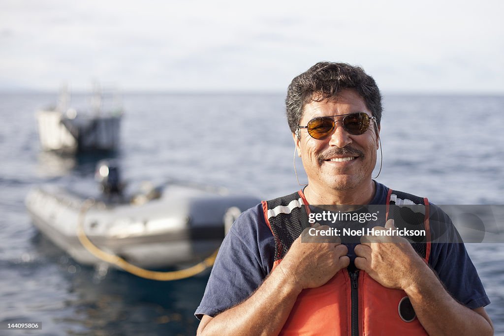 A ship's crewman with inflatable boat behind him