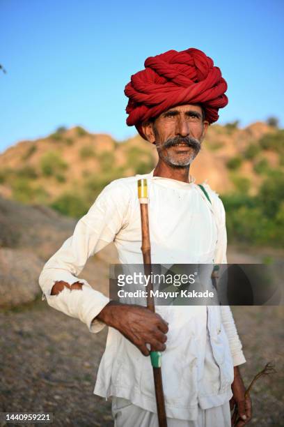 portrait of a senior rabari  man shepherd wearing a red turban - nomad cattle herder from rajasthan stock-fotos und bilder