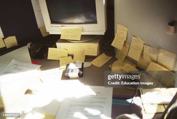 Desk, Computer And Wall Covered With Post-It Notes.