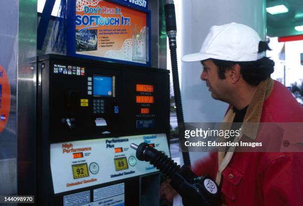 Man Using Automated Pump At Gas Station, Accepts Credit/ Debit Cards.