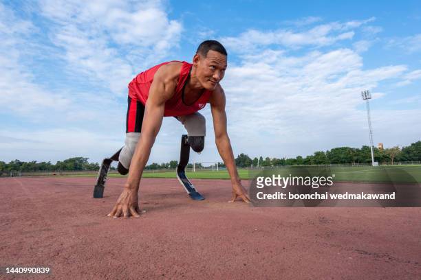 disabled man athlete ready for training with leg prosthesis. paralympic sport concept. - paralympics track stock pictures, royalty-free photos & images