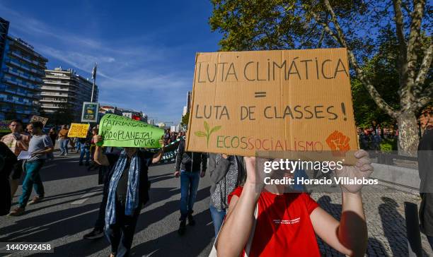 Demonstrators chant and hold placards at the rally convened by the Coalition "Unir contra o Fracasso Climático" , which brings together several...