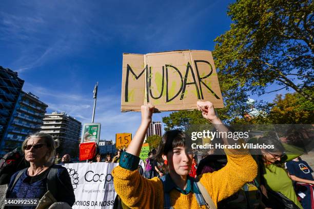 Demonstrators chant and hold placards at the rally convened by the Coalition "Unir contra o Fracasso Climático" , which brings together several...