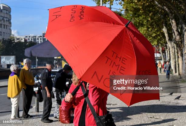 Demonstrator holds an umbrella with the inscription "The Time is Now" at the rally convened by the Coalition "Unir contra o Fracasso Climático" ,...