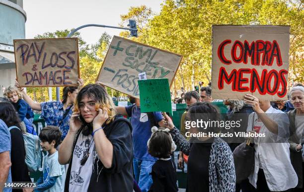 Demonstrators chant and hold placards at the rally convened by the Coalition "Unir contra o Fracasso Climático" , which brings together several...