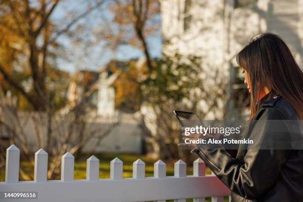 perito che ispeziona l'esterno della casa che circonda la recinzione a flushing, queens, ny. - flushing queens foto e immagini stock