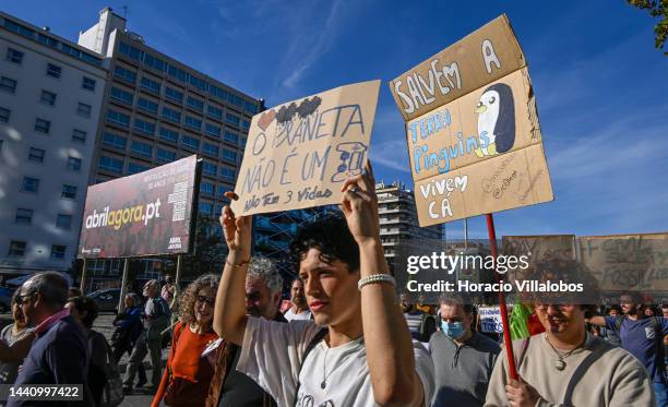 Demonstrators chant and hold placards at the rally convened by the Coalition "Unir contra o Fracasso Climático" , which brings together several...