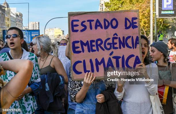 Demonstrators chant and hold placards at the rally convened by the Coalition "Unir contra o Fracasso Climático" , which brings together several...