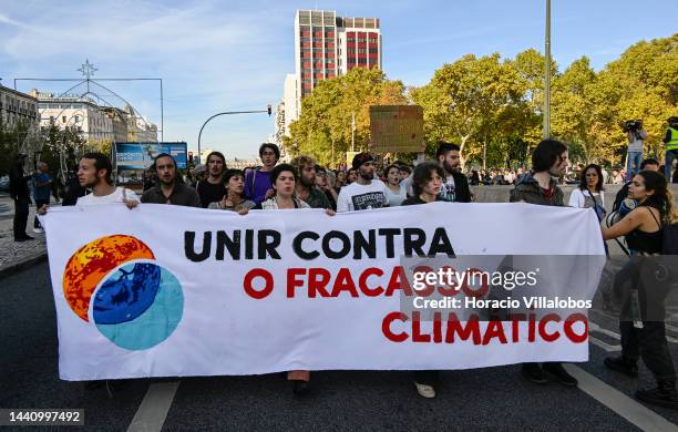 Demonstrators chant and walk behind a "Unite Against Climate Failure" banner at the rally convened by the Coalition "Unir contra o Fracasso...
