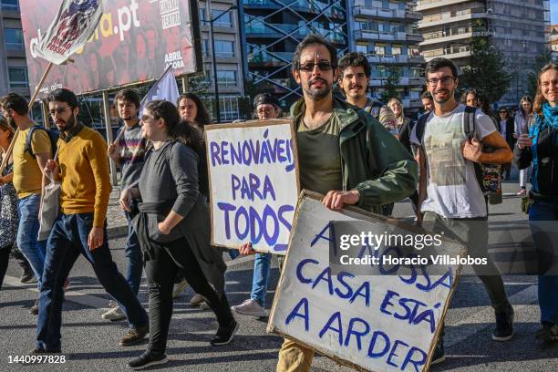 Demonstrators chant and hold placards at the rally convened by the Coalition "Unir contra o Fracasso Climático" , which brings together several...