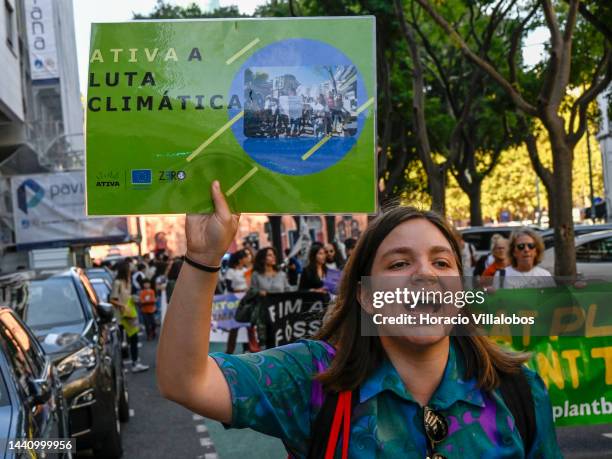 Demonstrators chant and hold placards at the rally convened by the Coalition "Unir contra o Fracasso Climático" , which brings together several...