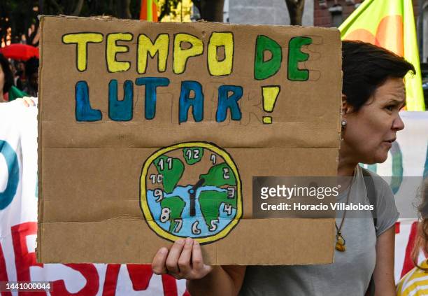 Demonstrator holds a placard with the inscription "Time to Fight!" at the rally convened by the Coalition "Unir contra o Fracasso Climático" , which...