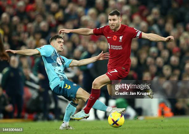 James Milner of Liverpool is challenged by Romain Perraud of Southampton during the Premier League match between Liverpool FC and Southampton FC at...