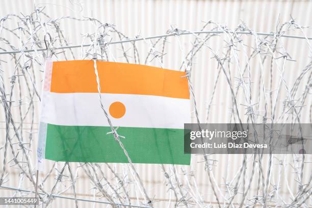 flag of niger on barbed wire - prison wall stock pictures, royalty-free photos & images