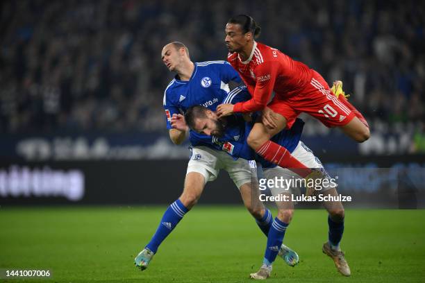 Leroy Sane of Bayern Munich collides with Dominick Drexler and Henning Matriciani of FC Schalke 04 during the Bundesliga match between FC Schalke 04...