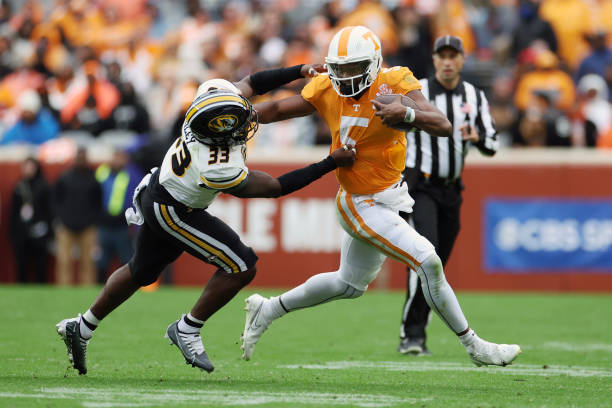 Hendon Hooker of the Tennessee Volunteers runs the ball with Chad Bailey of the Missouri Tigers defending in the first half at Neyland Stadium