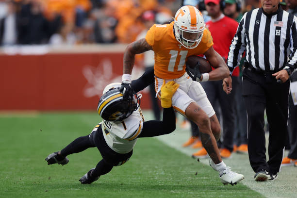 Jalin Hyatt of the Tennessee Volunteers stiff arms Jaylon Carlies of the Missouri Tigers while running out of bounds