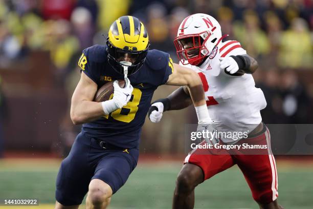 Colston Loveland of the Michigan Wolverines battles for extra yards after a first half catch against Caleb Tannor of the Nebraska Cornhuskers at...